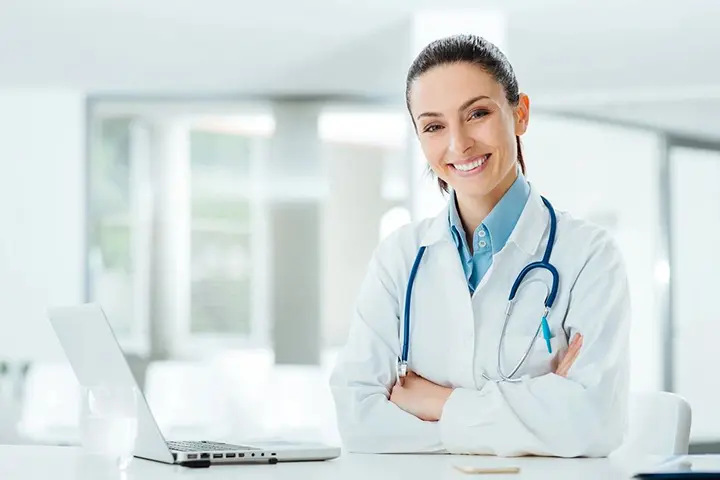 Confident female doctor at office desk